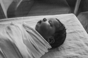 newborn baby in a hospital crib, black and white